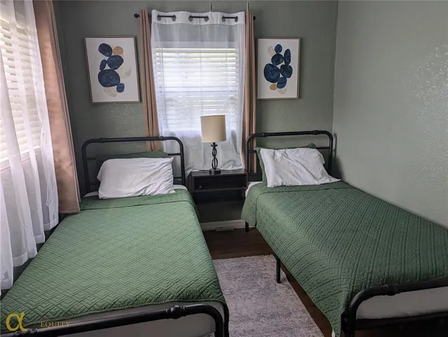 a bedroom with two beds and a painting on the wall