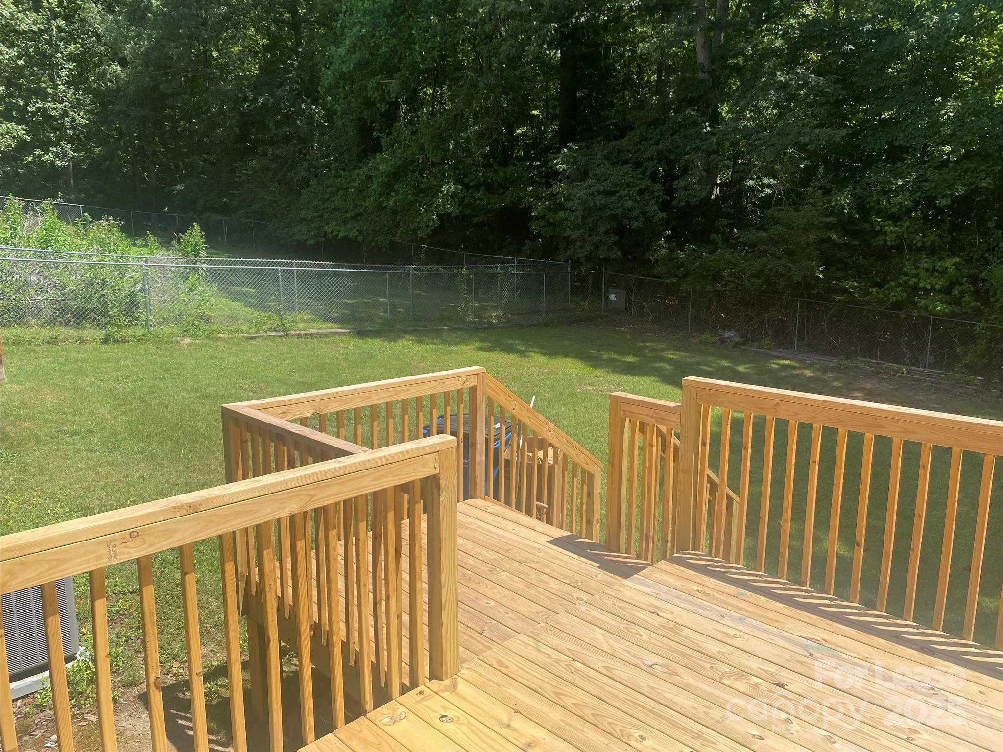 1427 Oak Hill Drive Morganton, NC 28655 - Photo 11 of 12 a view of a wooden deck and lake with trees in the background