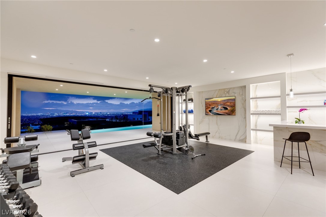 677 Overlook Rim Drive Henderson, NV 89012 - Photo 45 of 97 Floor-to-ceiling sliding glass doors seamlessly connect this modern home fitness space with panoramic skyline views.
