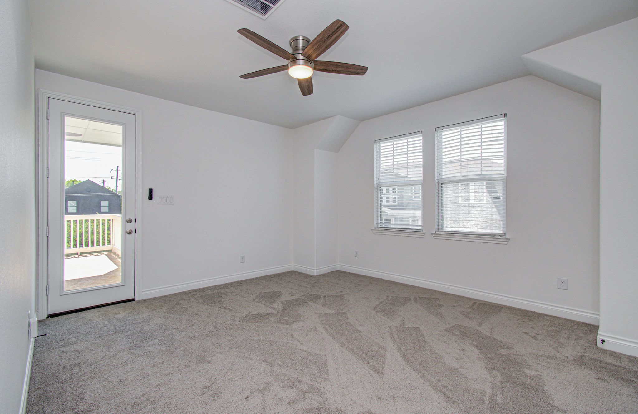 6621 North Main Street Houston, TX 77009 - Photo 19 of 41 This bright office/flex room features fresh carpeting, a modern ceiling fan, and ample natural light from two windows. A door leads to a large second story outdoor balcony, enhancing the space with a cozy, airy feel.