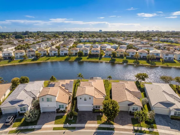 an aerial view of a house with a garden and lake view