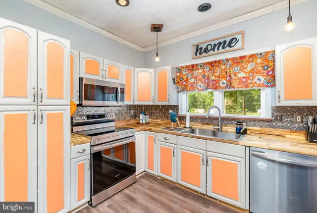 a kitchen with stainless steel appliances a stove sink and microwave