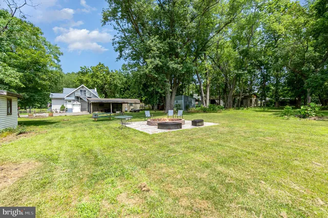 a view of yard with swimming pool and trees in the background