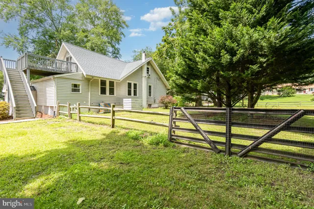 a view of a house with backyard and a tree