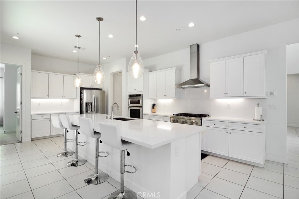 24336 Sterling Ranch Road West Hills, CA 91304 - Photo 14 of 40 a kitchen with stainless steel appliances kitchen island granite countertop a stove a sink a dining table and chairs
