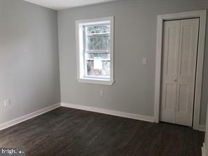 538 Newcomb Street Southeast Washington, DC 20032 - Photo 24 of 29 an empty room with wooden floor and windows