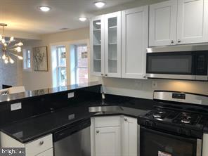 538 Newcomb Street Southeast Washington, DC 20032 - Photo 8 of 29 a kitchen with granite countertop white cabinets and black appliances