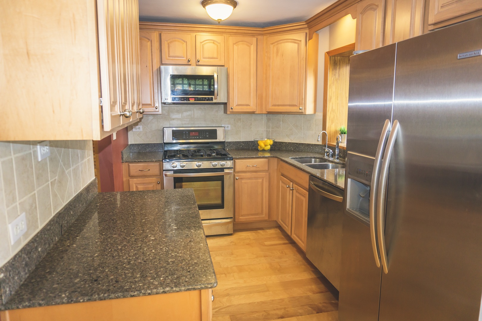28939 May Street Spring Grove, IL 60081 - Photo 6 of 28 a kitchen with stainless steel appliances granite countertop a stove a sink and a microwave