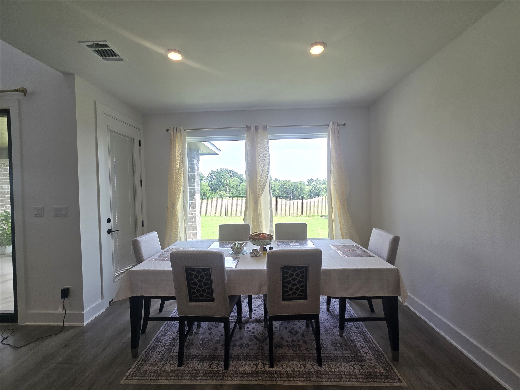 124 Ribera Drive Liberty Hill, TX 78642 - Photo 11 of 40 A refined dining space features wood flooring and a bright view of the backyard through large windows.