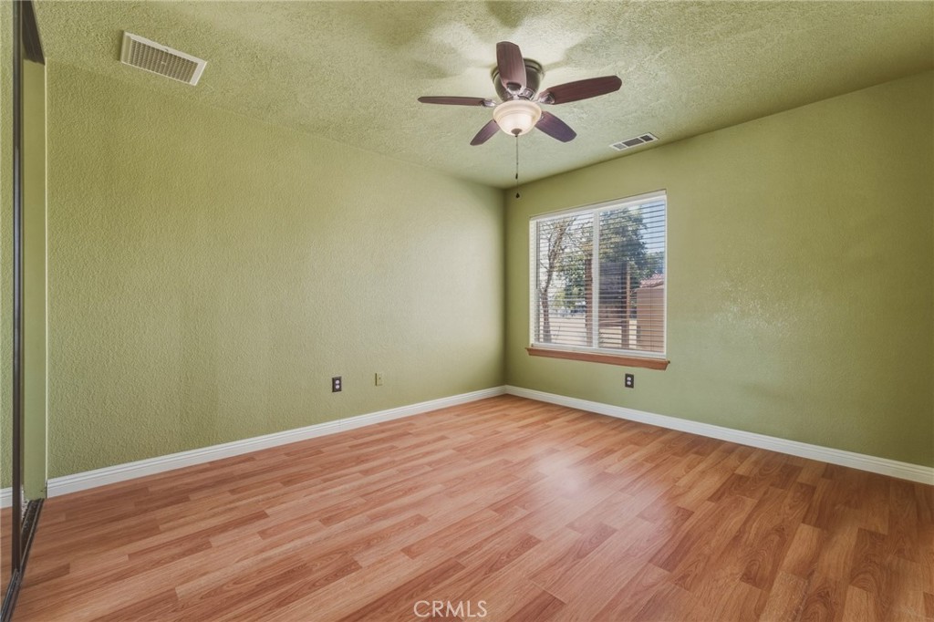 19501 Kinai Road Apple Valley, CA 92307 - Photo 37 of 49 an empty room with wooden floor and windows