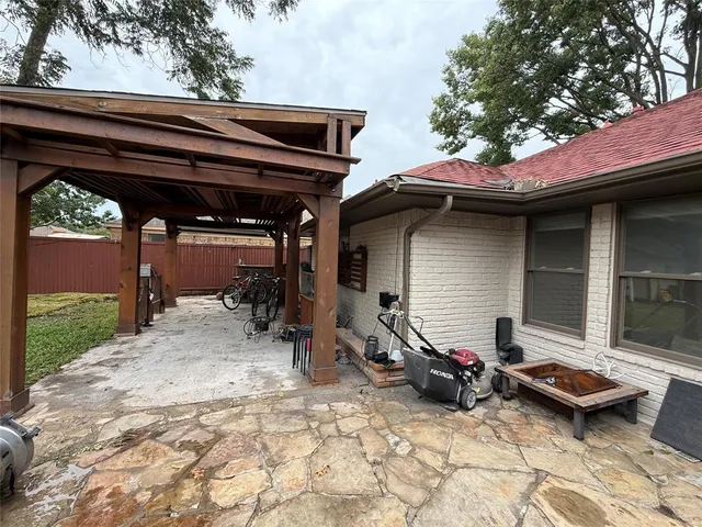 a front view of a house with large trees