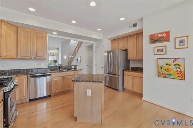 a kitchen with stainless steel appliances granite countertop a refrigerator and a stove top oven