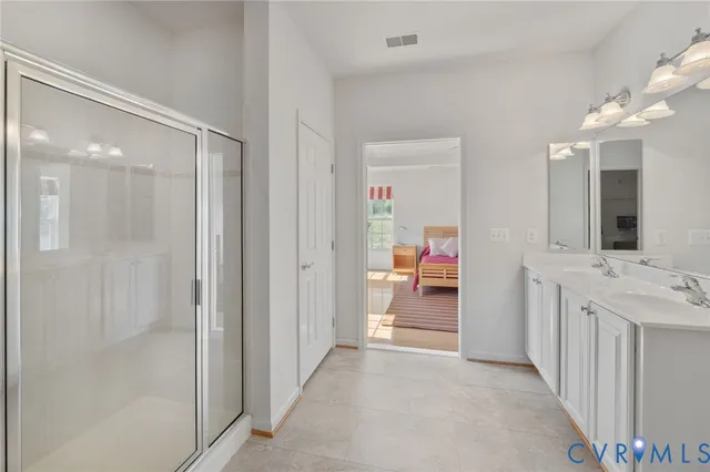 a en suite bathroom with a double vanity sink and a mirror