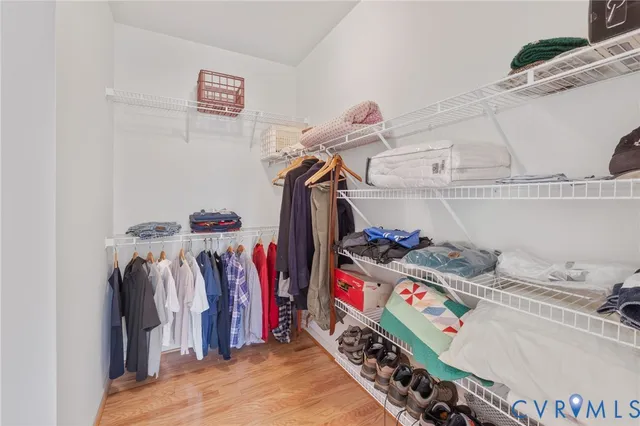 a view of walk in closet with clothes and shoes