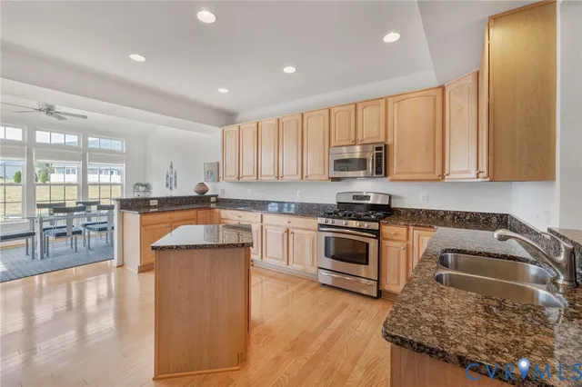 a kitchen with stainless steel appliances granite countertop a stove a sink and a refrigerator