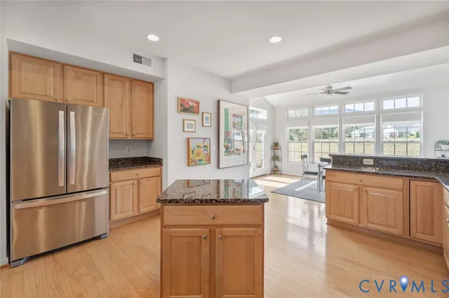 a kitchen with stainless steel appliances granite countertop a refrigerator a stove and a sink with large window