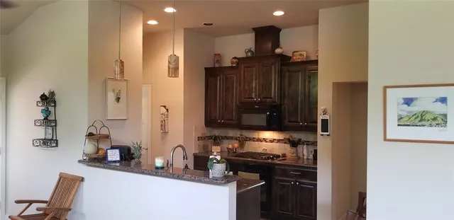 a kitchen with stainless steel appliances granite countertop a refrigerator and a stove