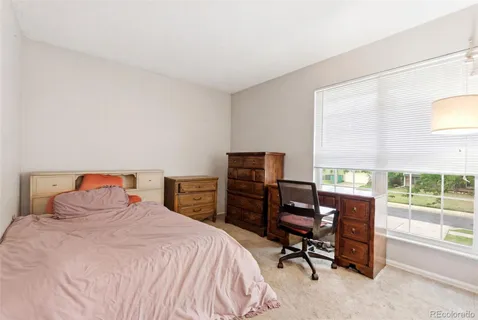 a bedroom with a bed and a desk