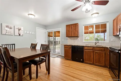 a kitchen with granite countertop a table chairs stove and cabinets