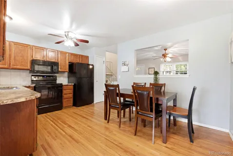 a kitchen with stainless steel appliances kitchen island granite countertop a table chairs and a refrigerator