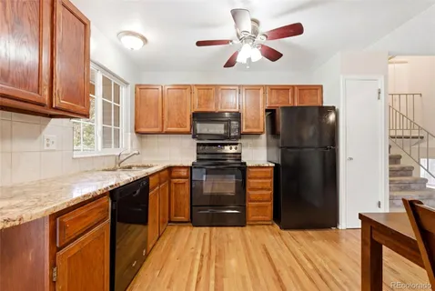 a kitchen with stainless steel appliances granite countertop a refrigerator a stove top oven a sink and dishwasher