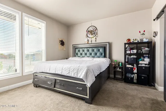 a bed sitting in a bedroom next to a window