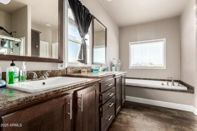 a bathroom with a granite countertop sink and a bathtub