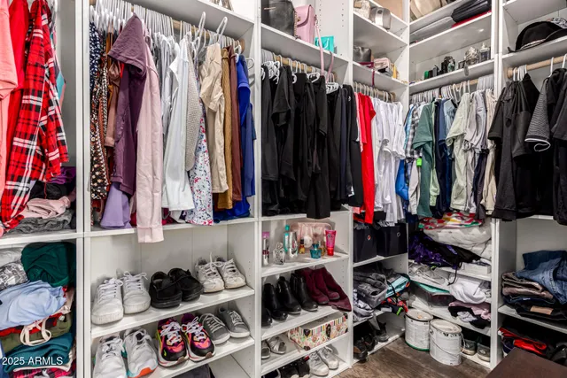 a view of walk in closet with clothes and shoes