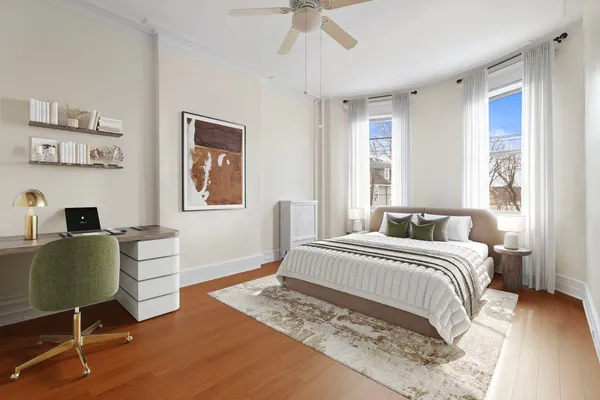 a view of an empty room with wooden floor ceiling fan