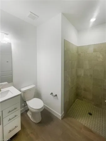 a bathroom with a granite countertop toilet a sink a shower and a mirror