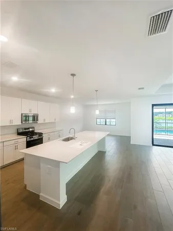 a kitchen with stainless steel appliances a sink a stove a refrigerator and cabinets
