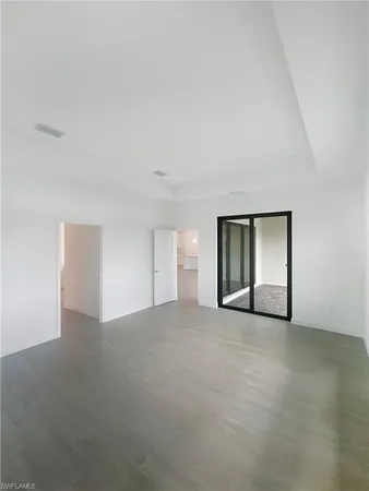 an empty room with a window and a kitchen space