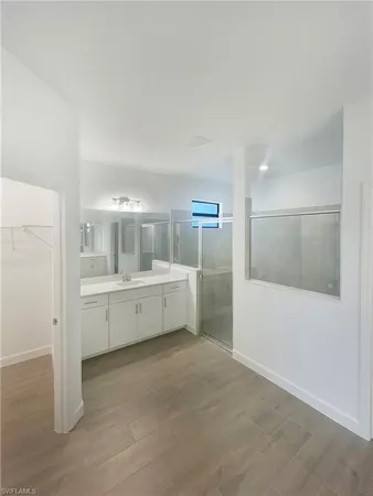 a bathroom with a double vanity sink toilet mirror and bathtub