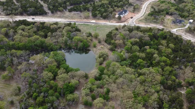 an aerial view of residential house with outdoor space and trees all around
