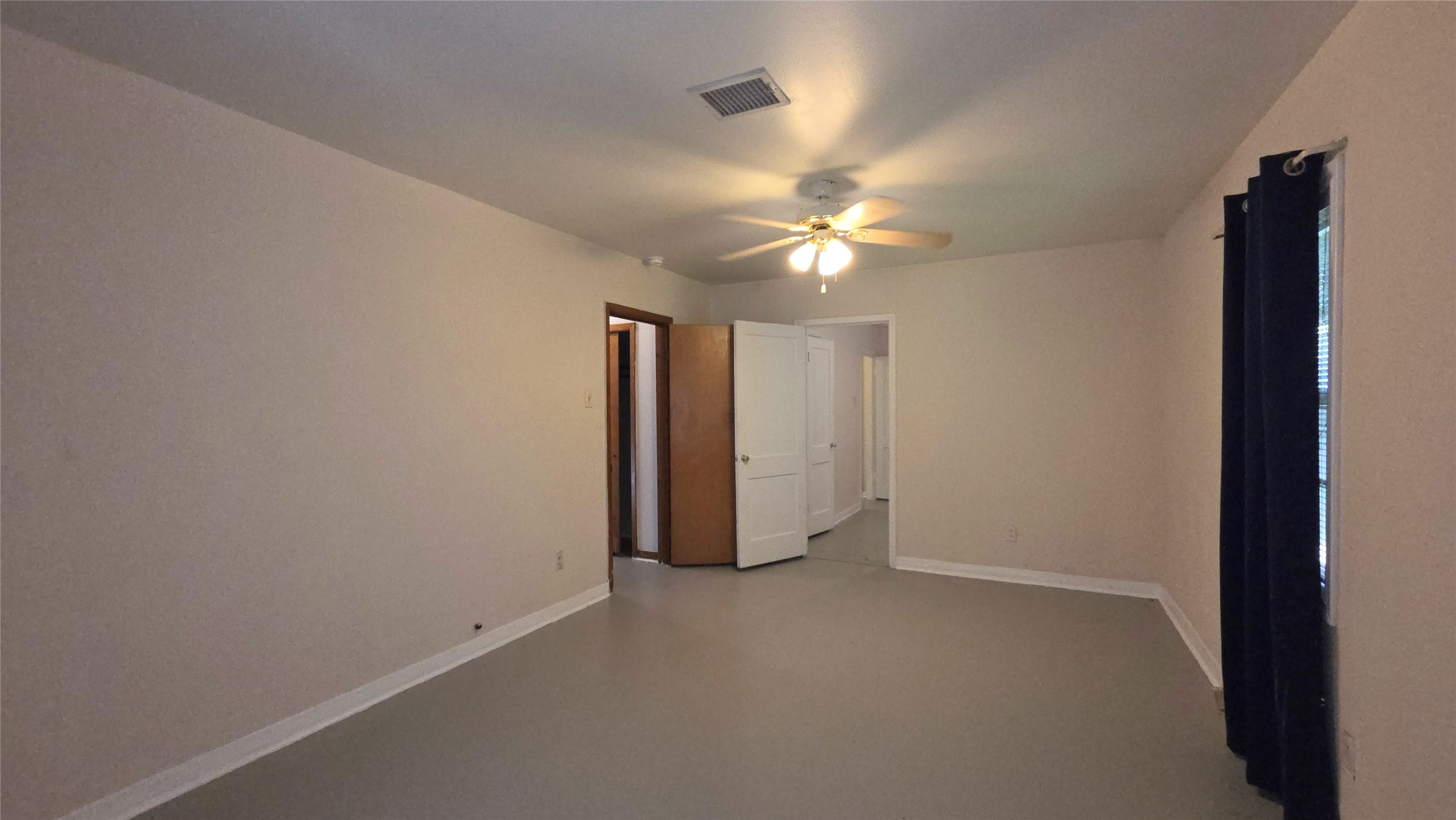 8510 Cowart Street Houston, TX 77029 - Photo 11 of 12 an empty room with a ceiling fan and window