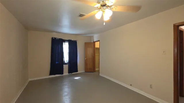 an empty room with closet and a chandelier fan