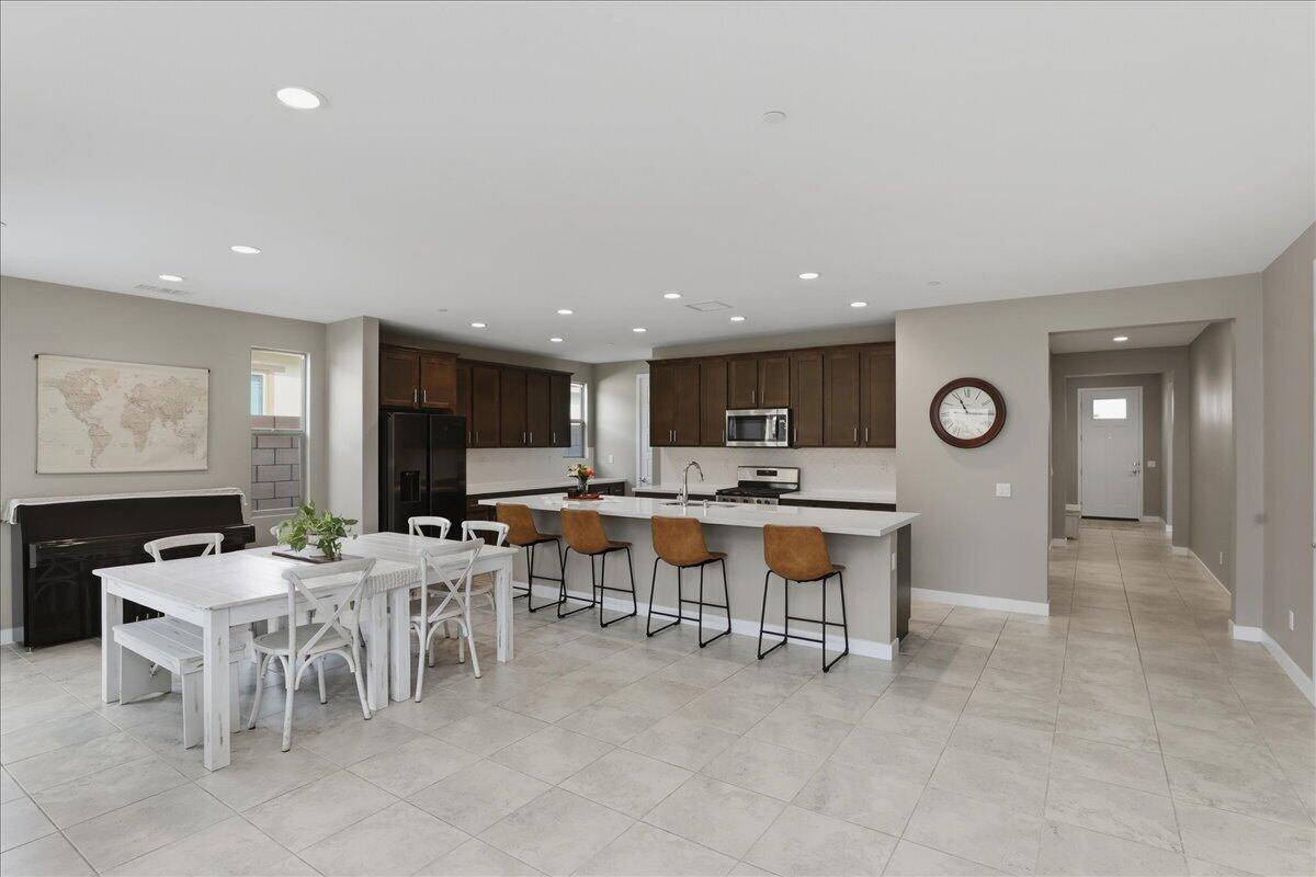 73721 Raphael Drive Palm Desert, CA 92211 - Photo 16 of 54 a large dining hall with stainless steel appliances lots of white furniture a window and a fireplace