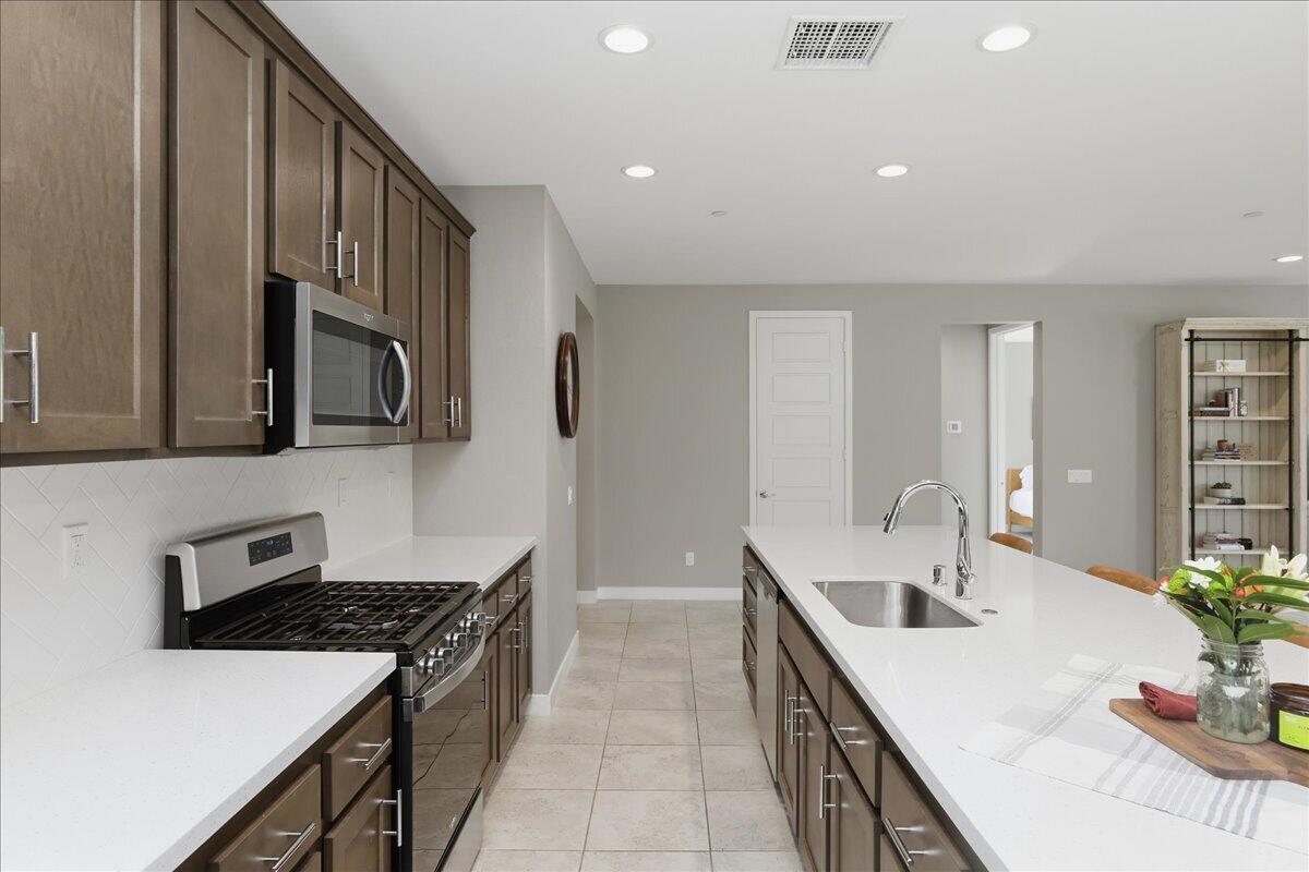 73721 Raphael Drive Palm Desert, CA 92211 - Photo 19 of 54 a kitchen with stainless steel appliances a sink stove and cabinets