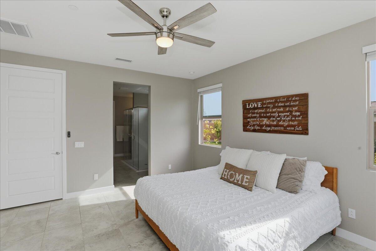 73721 Raphael Drive Palm Desert, CA 92211 - Photo 27 of 54 a bedroom with a large bed and a chandelier