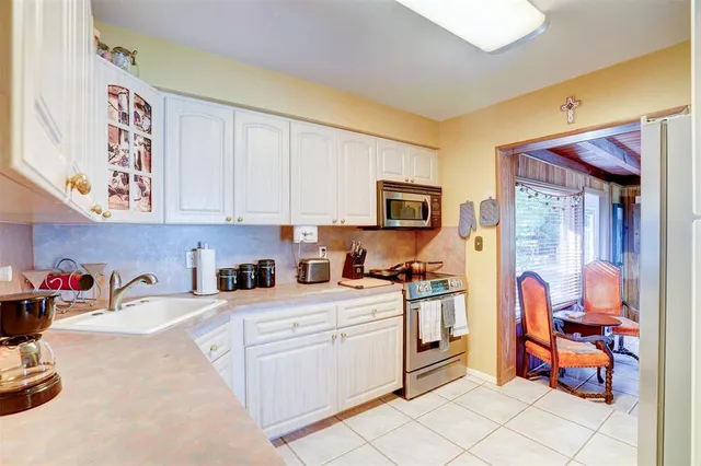 a kitchen with stainless steel appliances granite countertop a refrigerator and a stove