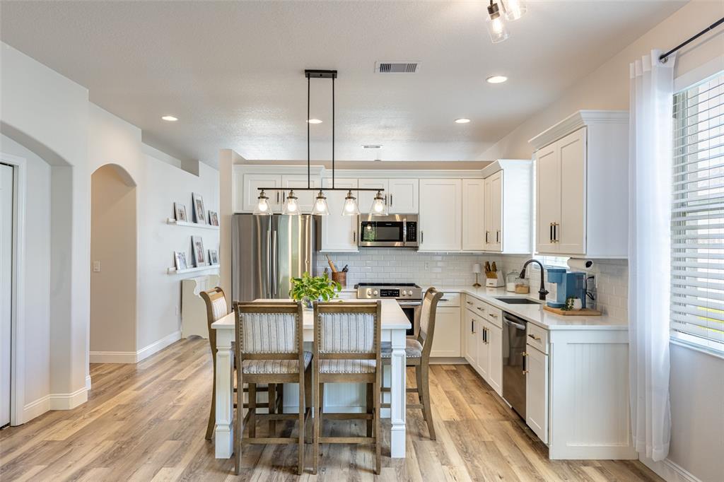 4136 Little Gap Loop Ellenton, FL 34222 - Photo 2 of 50 a kitchen with stainless steel appliances a dining table chairs refrigerator and microwave