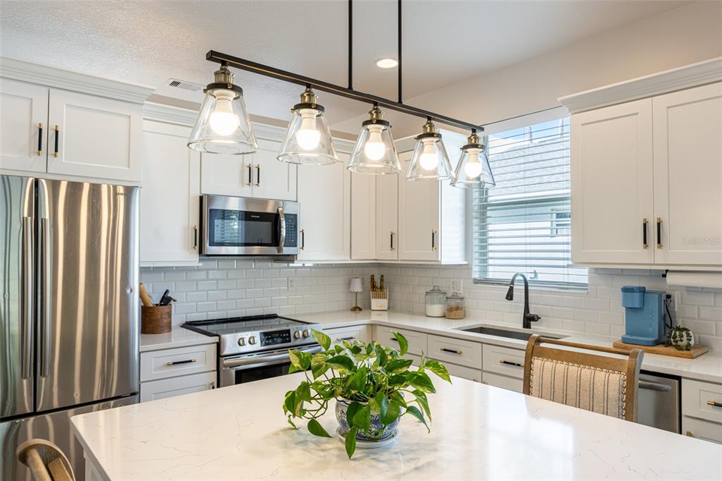 4136 Little Gap Loop Ellenton, FL 34222 - Photo 4 of 50 a kitchen with stainless steel appliances a refrigerator sink and white cabinets