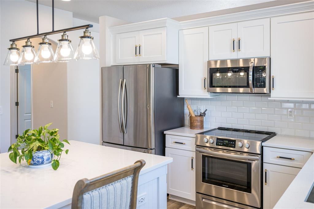 4136 Little Gap Loop Ellenton, FL 34222 - Photo 5 of 50 a kitchen with stainless steel appliances granite countertop a stove a refrigerator and a microwave