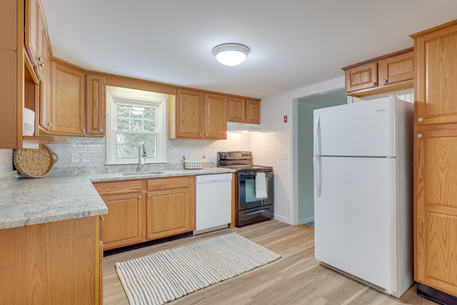 98 Long Road Harwich, MA 02645 - Photo 4 of 31 a kitchen with granite countertop a refrigerator a sink and white cabinets