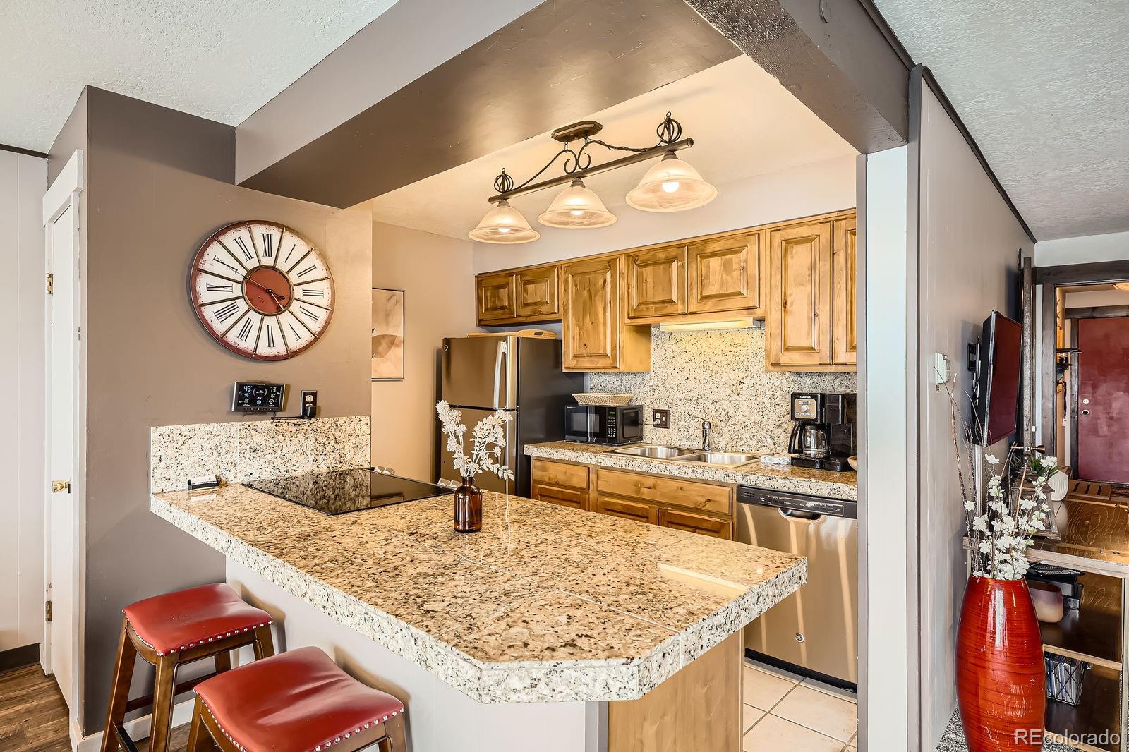 120 E Lane, Unit 109 Dillon, CO 80435 - Photo 12 of 39 a kitchen with stainless steel appliances granite countertop a sink and a refrigerator