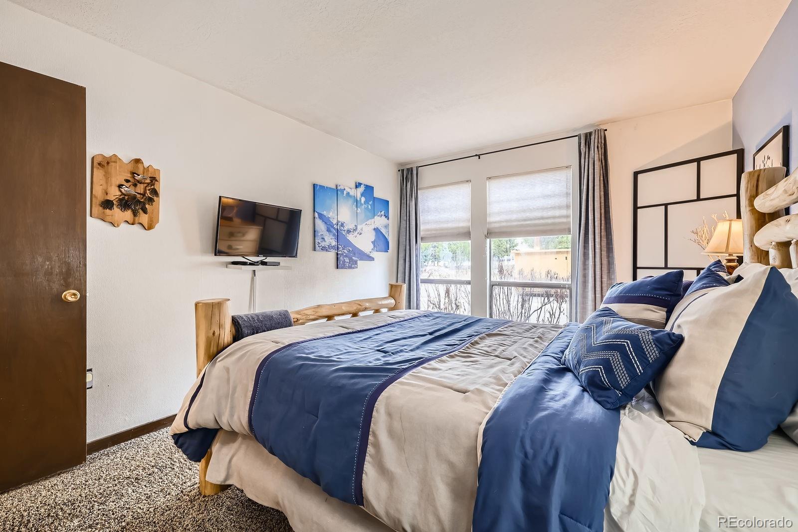 120 E Lane, Unit 109 Dillon, CO 80435 - Photo 21 of 39 a bedroom with a bed window and a flat screen tv