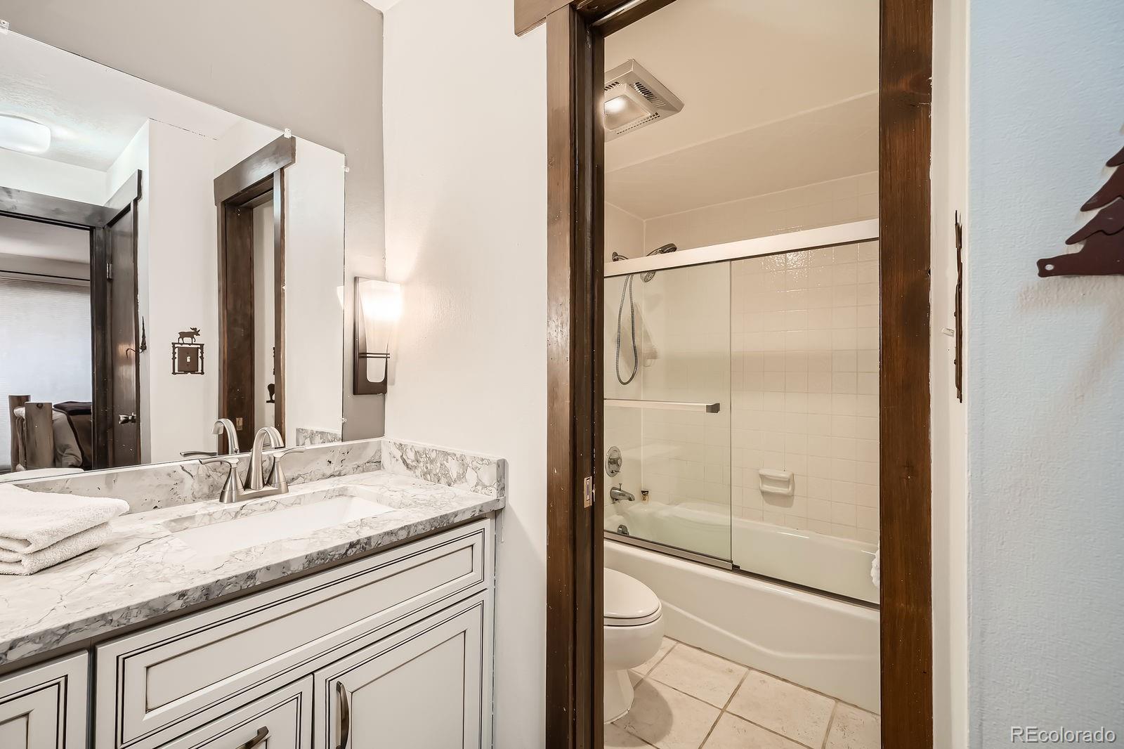 120 E Lane, Unit 109 Dillon, CO 80435 - Photo 22 of 39 a bathroom with a granite countertop sink two mirror and shower