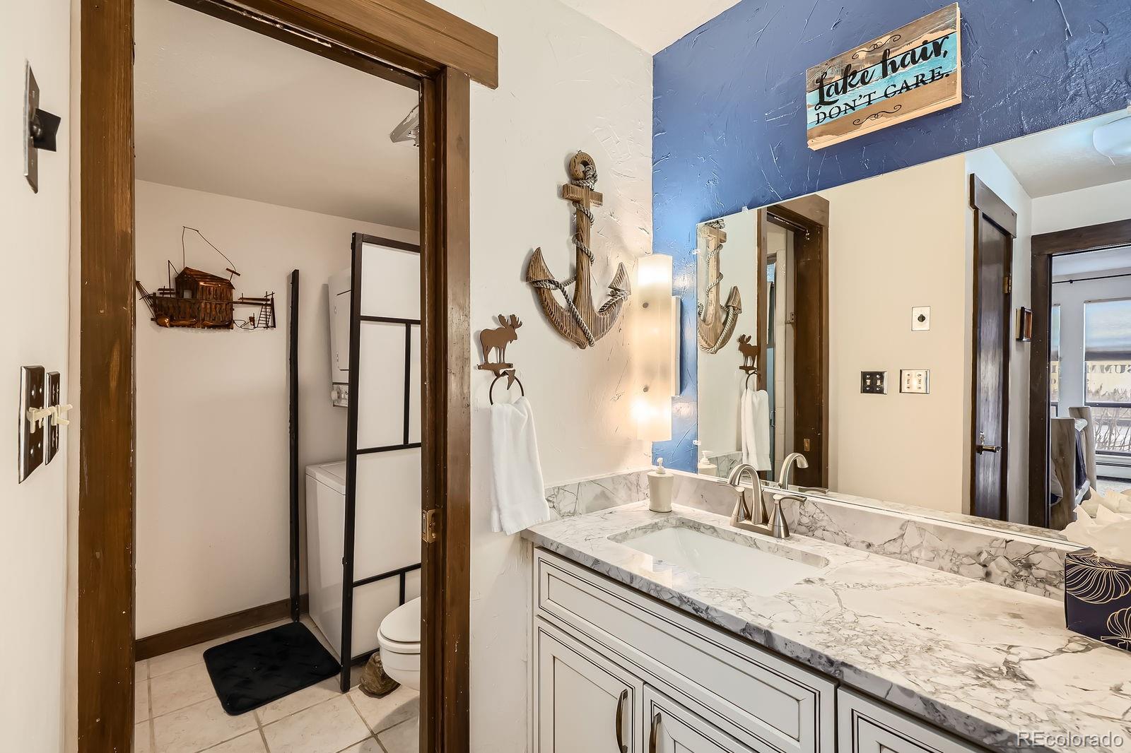 120 E Lane, Unit 109 Dillon, CO 80435 - Photo 24 of 39 a bathroom with a granite countertop sink and a mirror