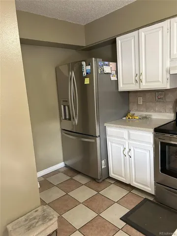 a kitchen with a refrigerator sink and cabinets