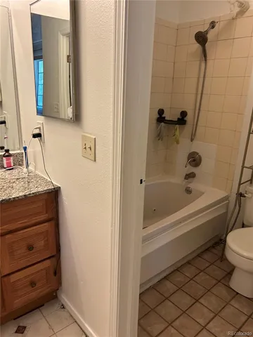 a bathroom with a granite countertop toilet a sink and a bathtub